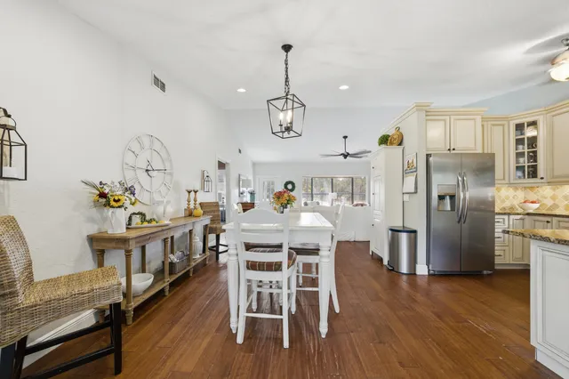 a kitchen with granite countertop a refrigerator stove top oven and sink