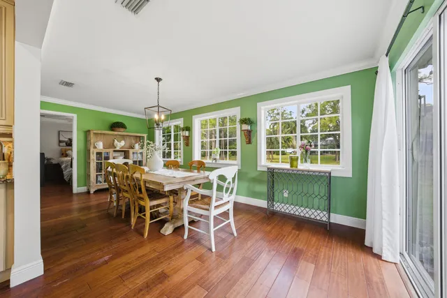 a dining room with furniture window and wooden floor