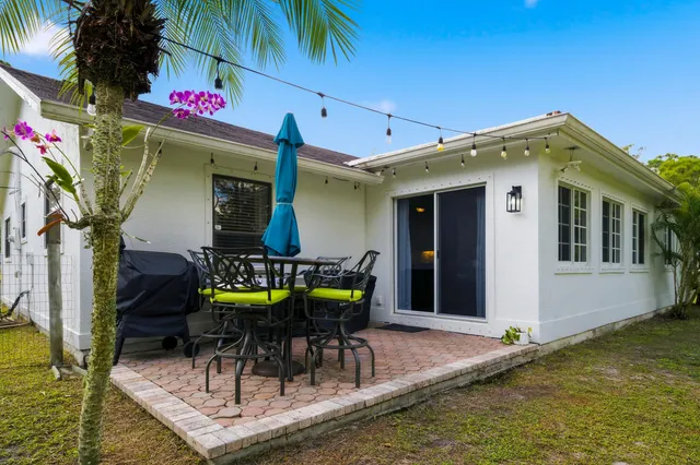 a view of a table and chairs in backyard of the house