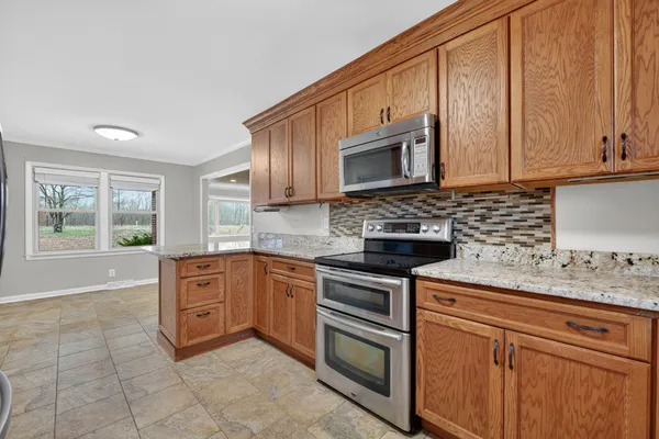 a kitchen with granite countertop a stove sink and microwave