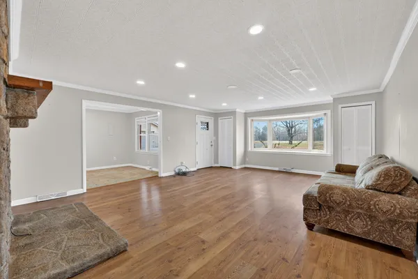 a living room with furniture and a window with wooden floor
