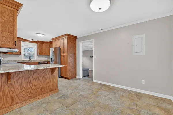 a view of kitchen with stainless steel appliances granite countertop cabinets and window