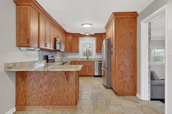 a kitchen with stainless steel appliances granite countertop a stove a sink and a refrigerator