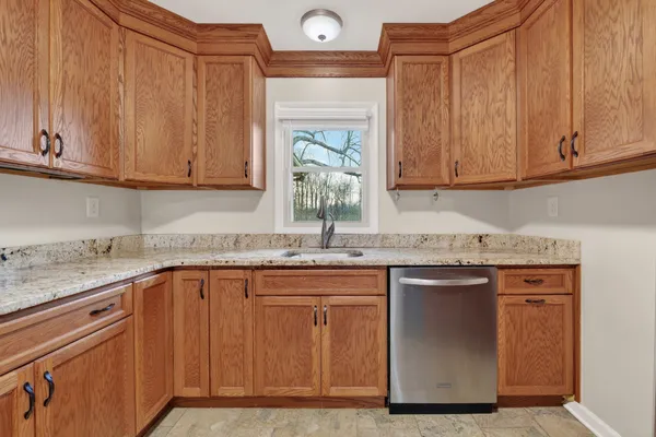 a kitchen with granite countertop stainless steel appliances sink and cabinets