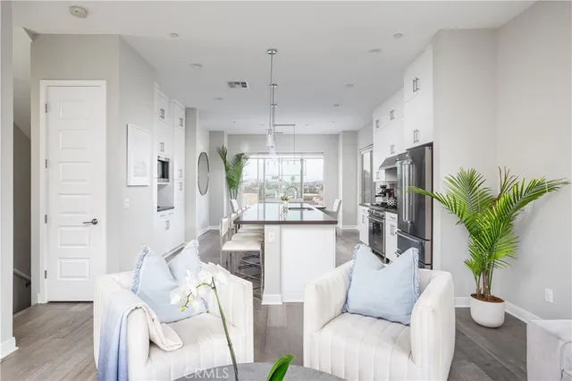 a living room with furniture a large window and a wooden floor