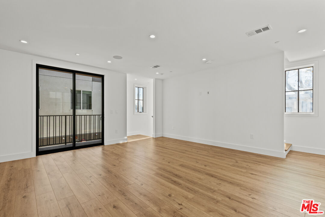 5536 Tova Road Sherman Oaks, CA 91411 - Photo 7 of 15 a view of an empty room with wooden floor and windows