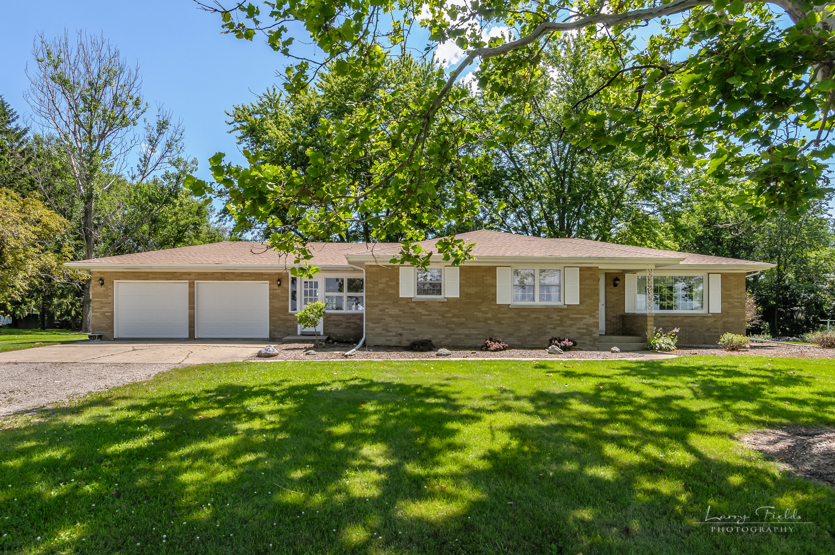 a front view of a house with a yard and trees