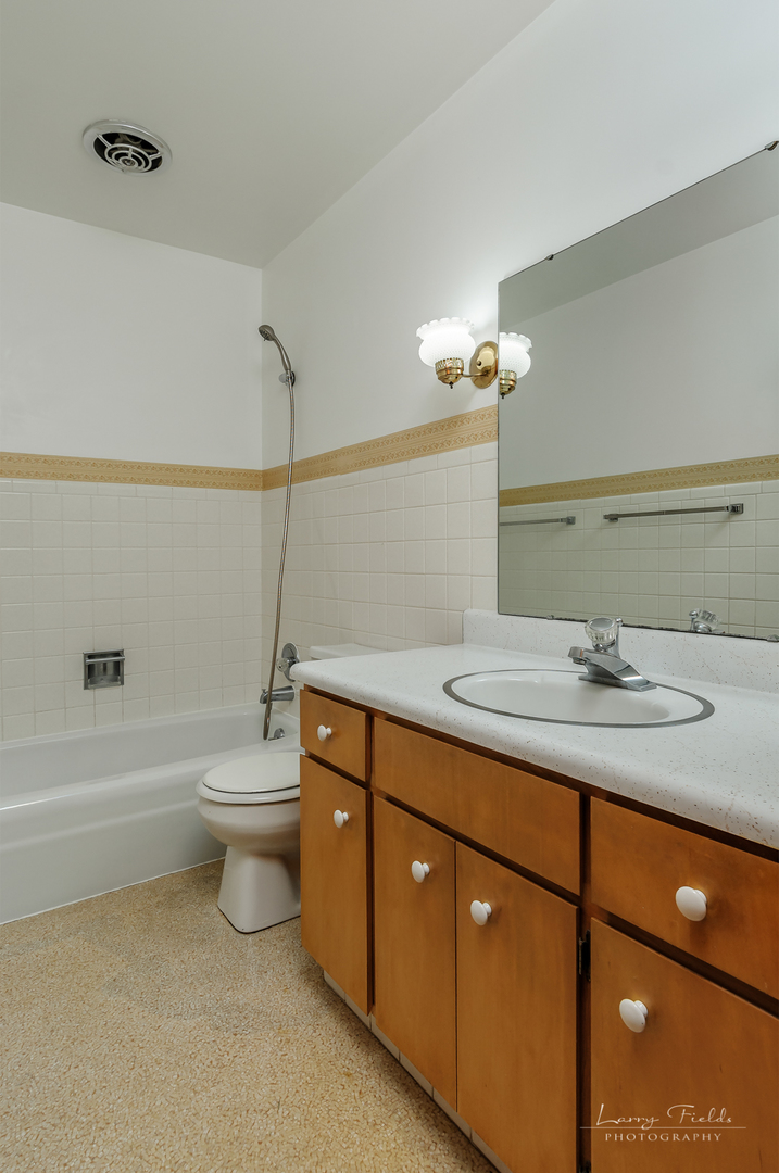 4682 East 29th Road Sandwich, IL 60548 - Photo 10 of 18 a bathroom with a granite countertop sink a toilet and bathtub