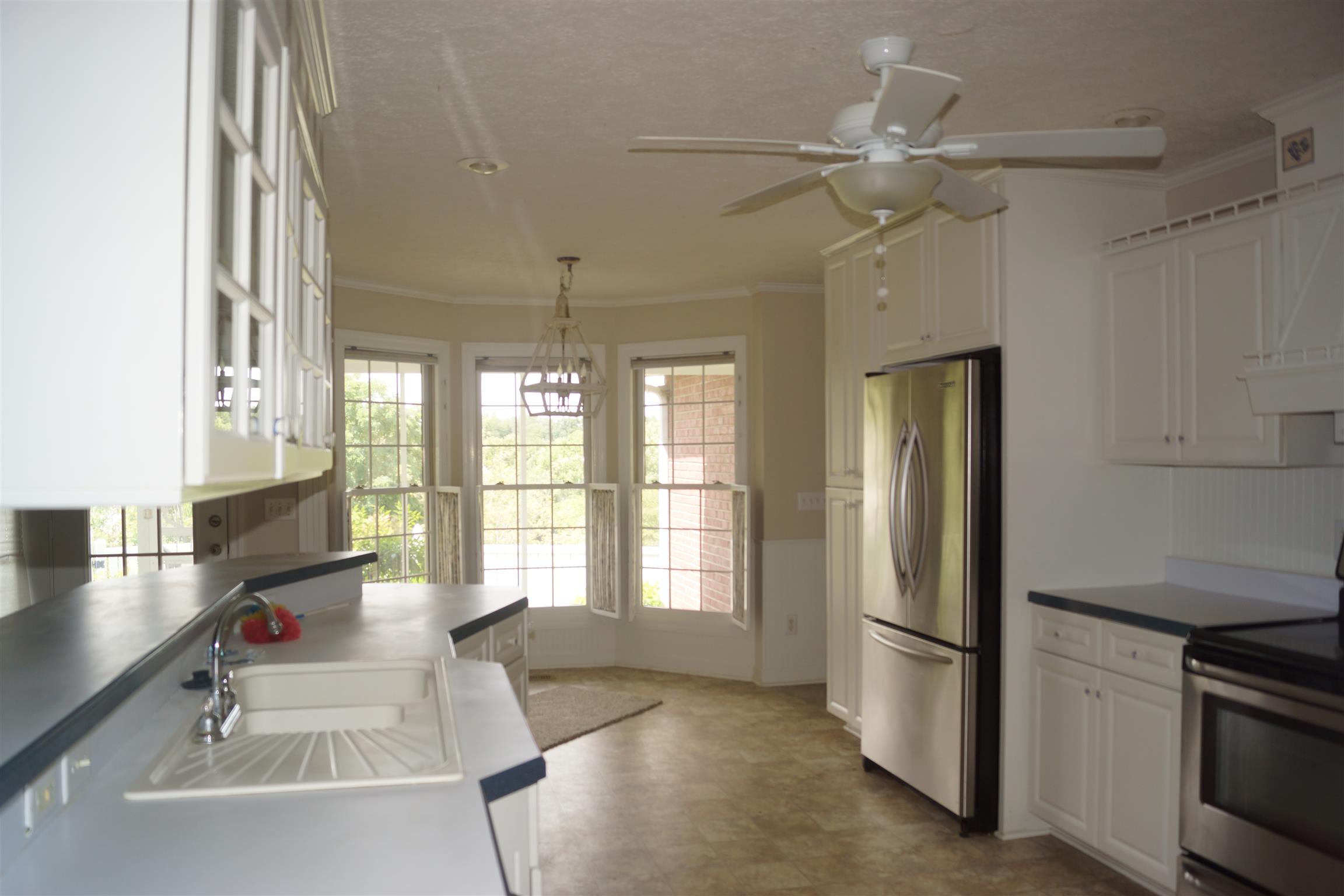 Large kitchen with stainless steel appliances, including refrigerator.