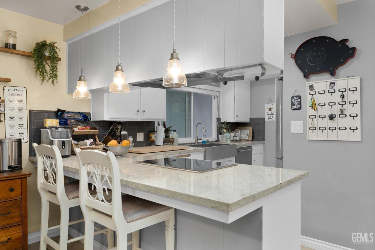Undisclosed Address Bakersfield, CA 93309 - Photo 18 of 33 a kitchen with a sink a stove and chairs