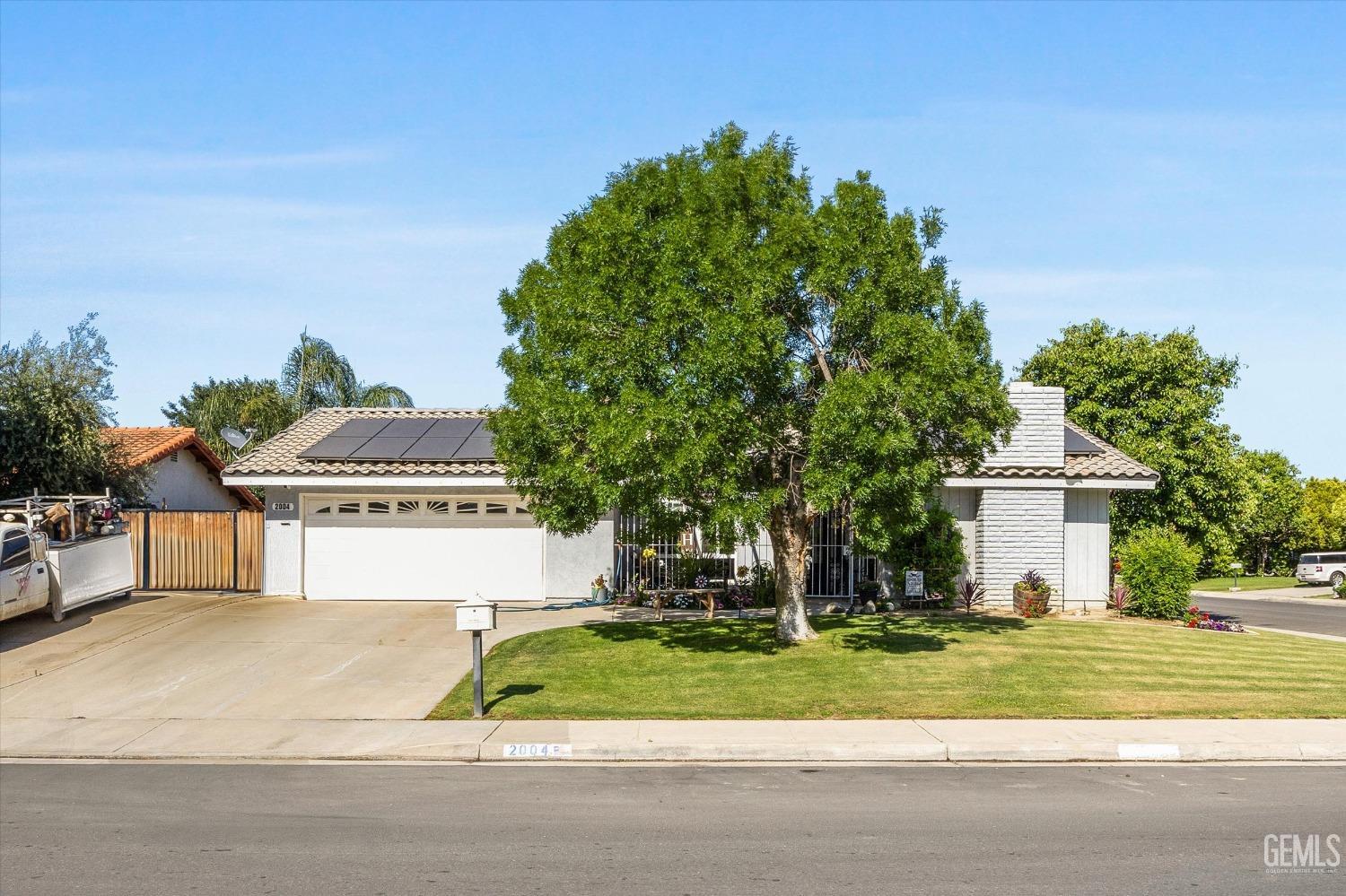 Undisclosed Address Bakersfield, CA 93309 - Photo 2 of 33 a front view of a house with a garage and a yard