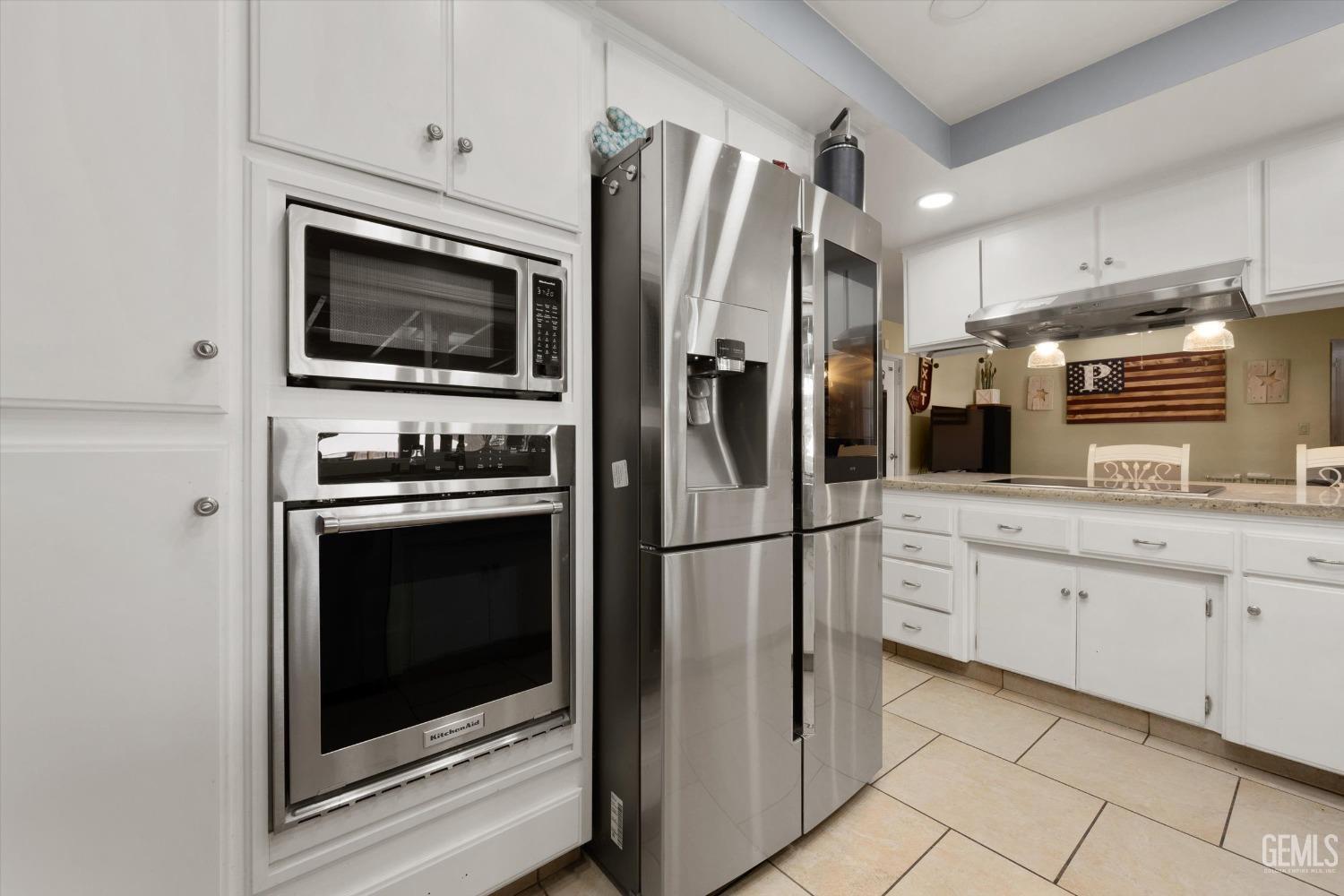 Undisclosed Address Bakersfield, CA 93309 - Photo 21 of 33 a kitchen with stainless steel appliances white cabinets a stove and a refrigerator