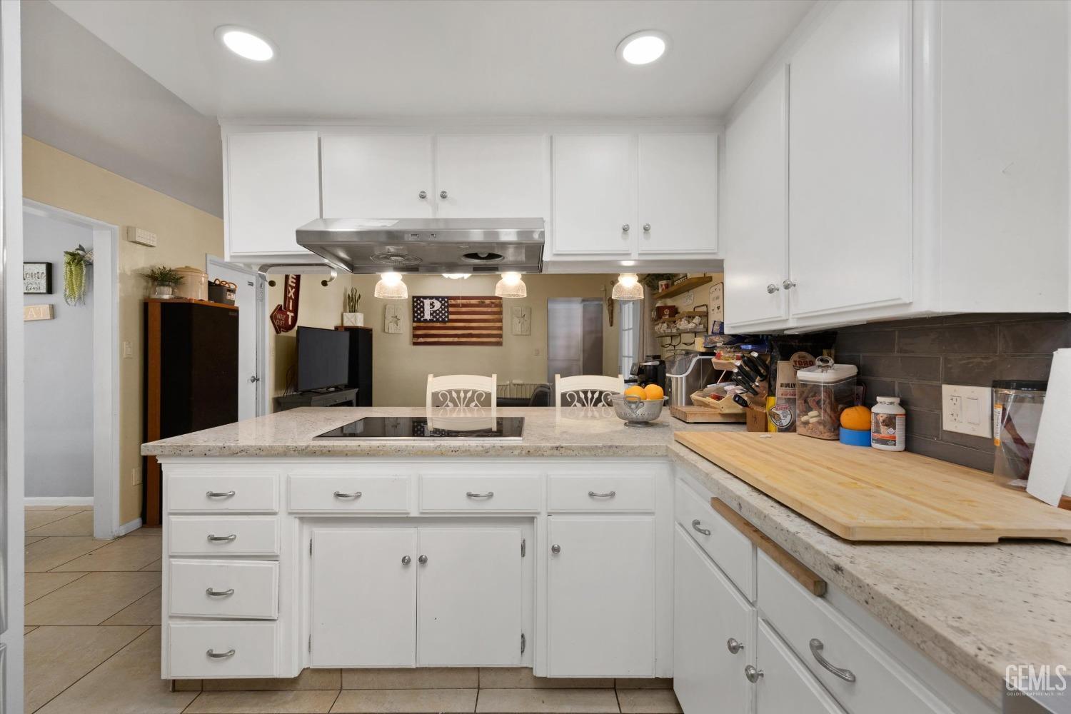 Undisclosed Address Bakersfield, CA 93309 - Photo 22 of 33 a kitchen with granite countertop white cabinets and stainless steel appliances