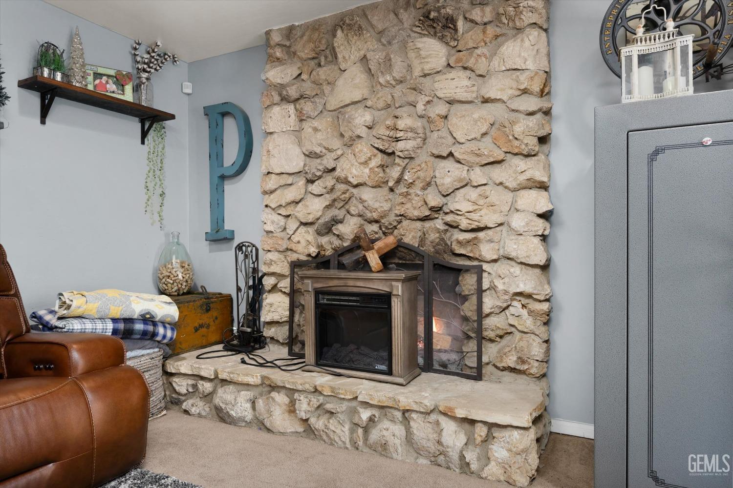 Undisclosed Address Bakersfield, CA 93309 - Photo 10 of 33 a living room with a fireplace and a stove top oven