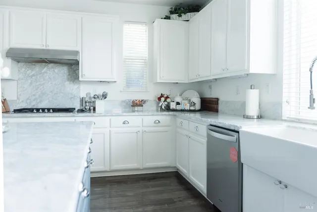 a kitchen with granite countertop white cabinets and white appliances
