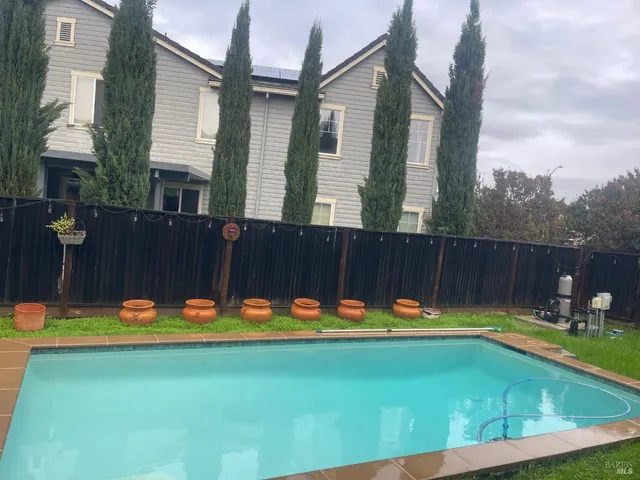 a view of a swimming pool with a yard and sitting area