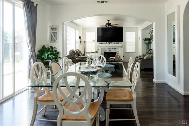 a view of a dining room with furniture a rug and wooden floor