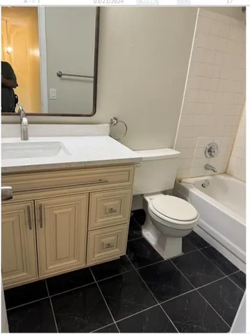 a bathroom with a toilet a sink and mirror