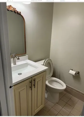 a bathroom with a granite countertop toilet sink and mirror
