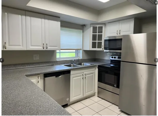 a kitchen with stainless steel appliances granite countertop a refrigerator and a stove top oven