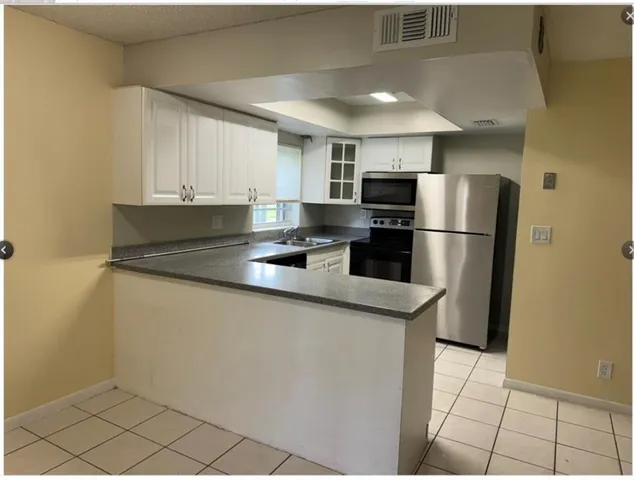 a kitchen with stainless steel appliances granite countertop a refrigerator a stove a sink and a refrigerator