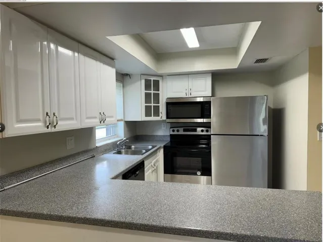 a kitchen with a refrigerator and a stove top oven