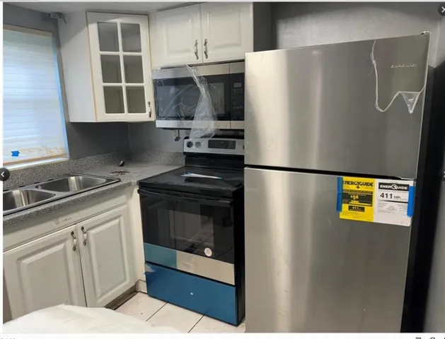 a kitchen with stainless steel appliances a refrigerator a sink and a stove