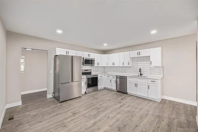 a kitchen with white cabinets stainless steel appliances and sink