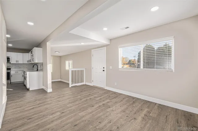 a kitchen with cabinets stainless steel appliances and wooden floor