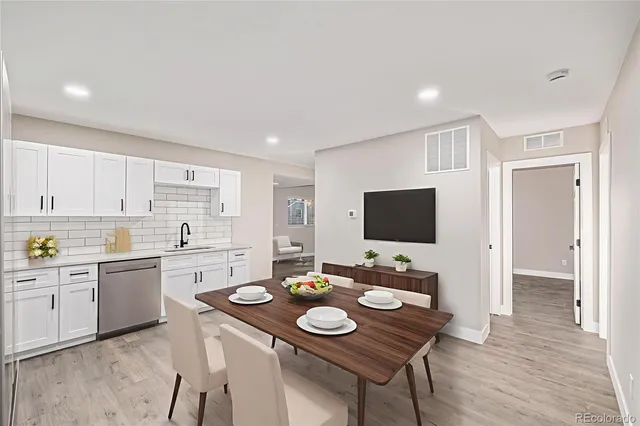 a open kitchen with stainless steel appliances granite countertop a stove a sink a refrigerator and a dining table with wooden floor