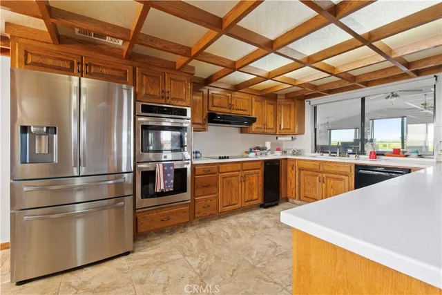 a kitchen with stainless steel appliances granite countertop a refrigerator a sink and white cabinets