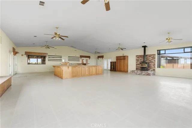 an empty room with fireplace and windows