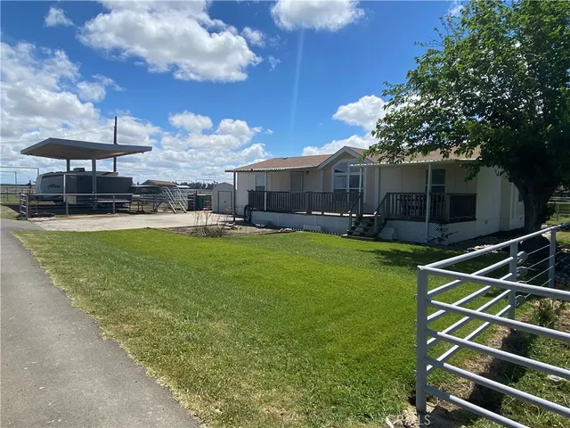 a view of a house with a backyard and sitting area