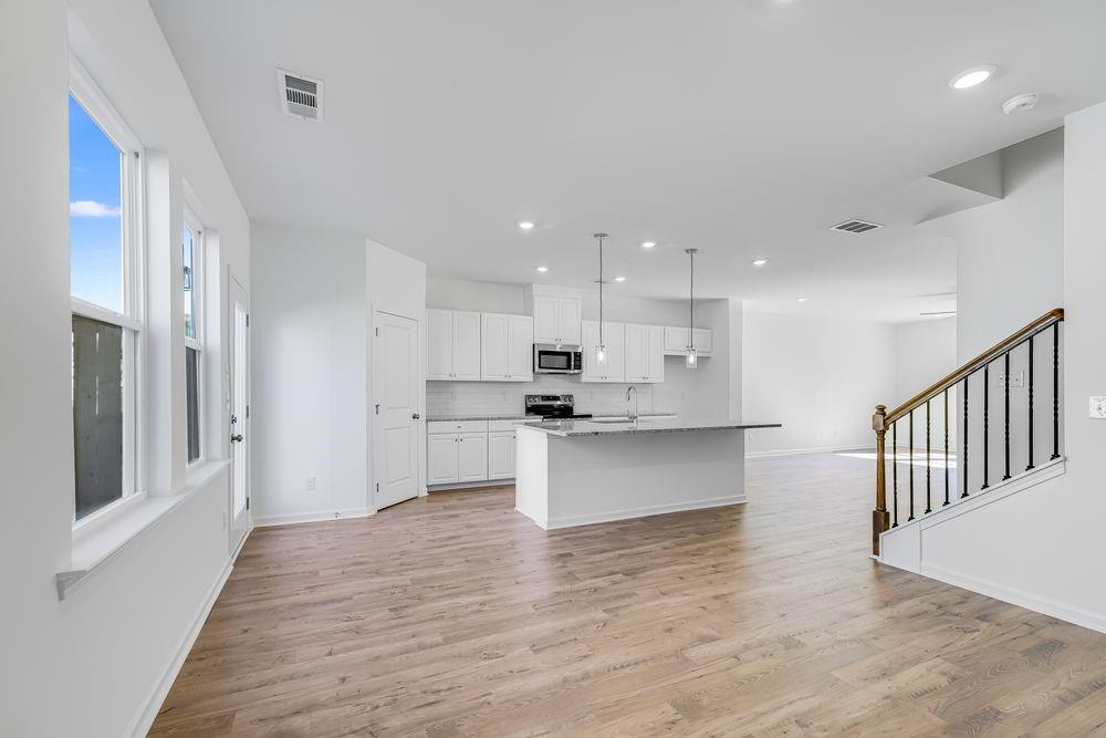 6117 Wayburn Street Tucker, GA 30084 - Photo 17 of 48 a large kitchen with stainless steel appliances kitchen island a large counter top and a wooden floors