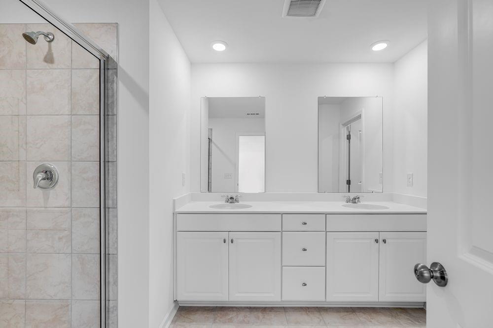 6117 Wayburn Street Tucker, GA 30084 - Photo 25 of 48 a bathroom with a double vanity sink a mirror and a bathtub