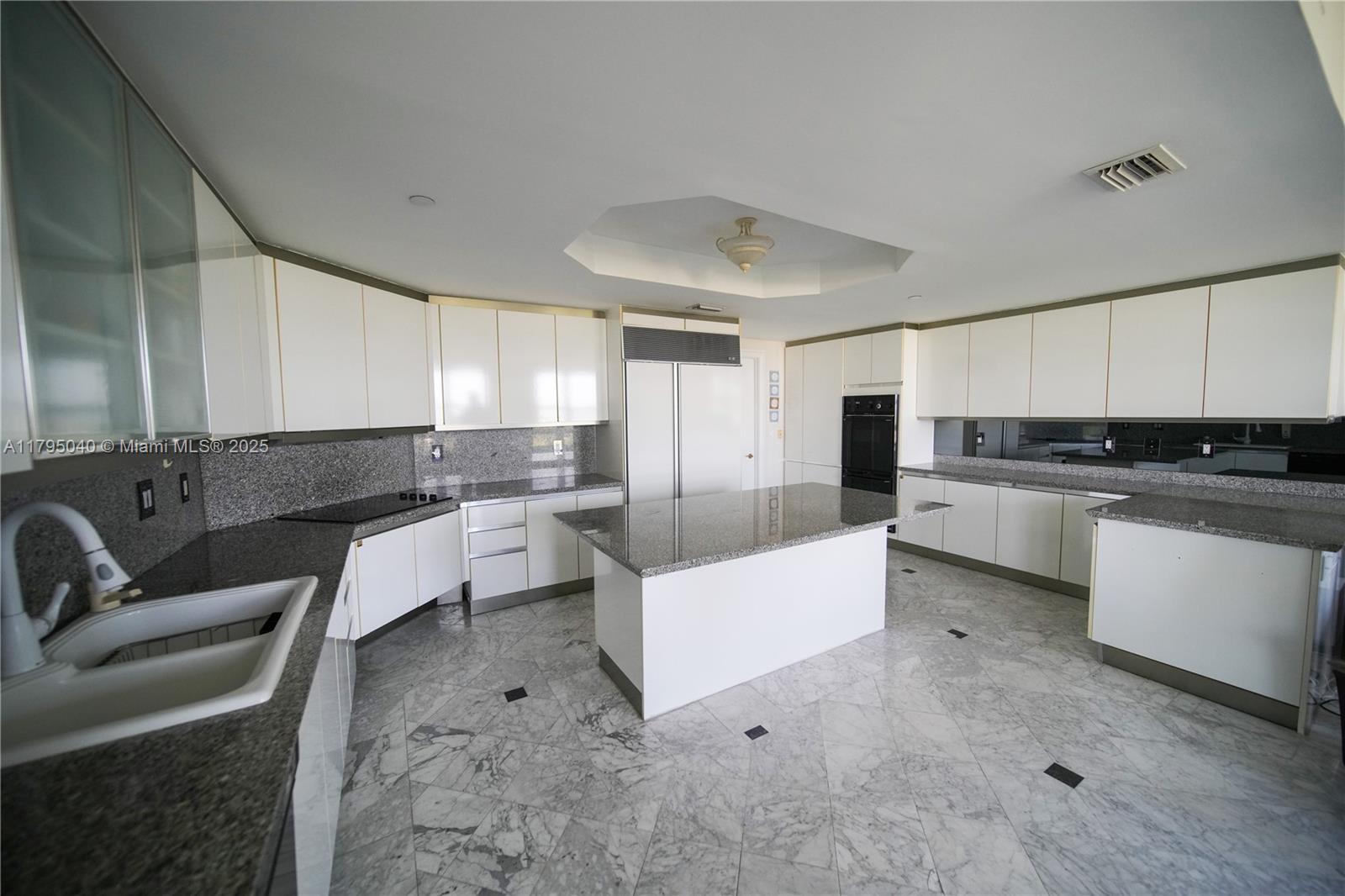 445 Grand Bay Drive, Unit 802 Key Biscayne, FL 33149 - Photo 8 of 24 a kitchen with white cabinets and stainless steel appliances