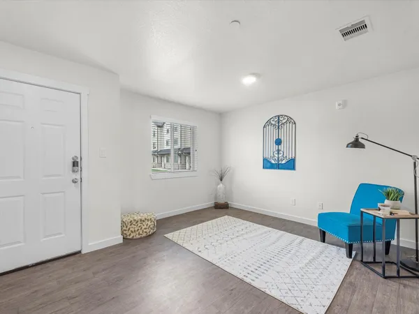 a view of an empty room with furniture and a window