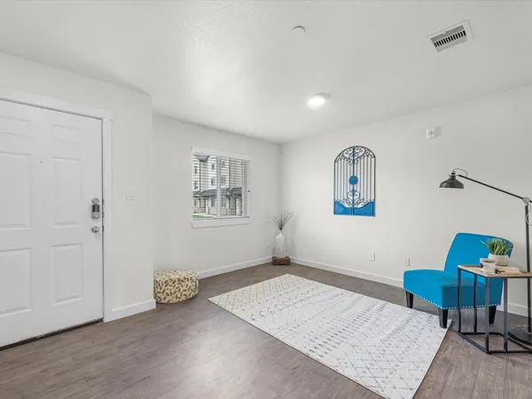 a view of an empty room with furniture and a window