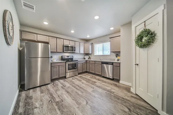 a kitchen with granite countertop stainless steel appliances a refrigerator and a sink