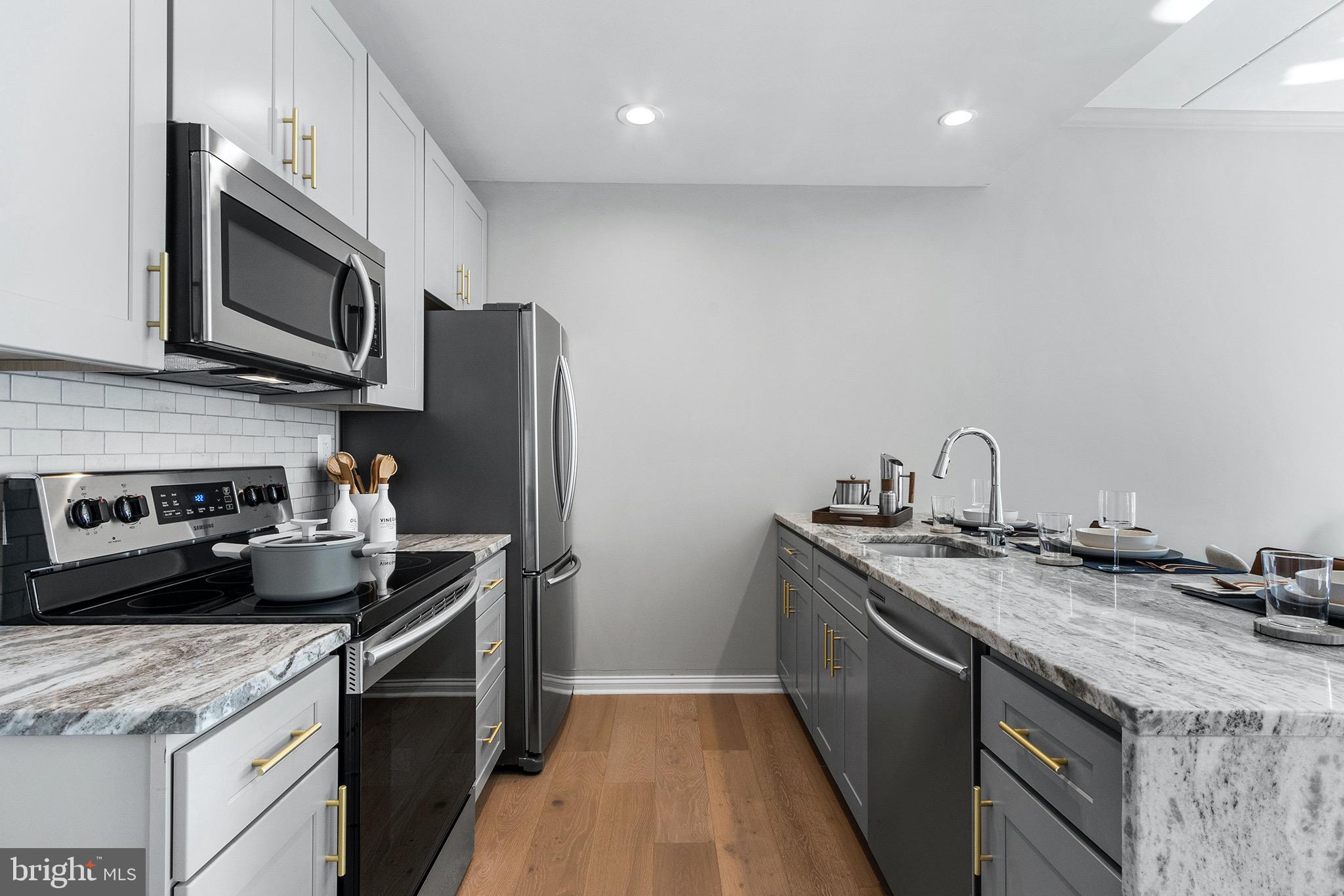 60 North 23rd Street, Unit 906 Philadelphia, PA 19103 - Photo 2 of 31 a kitchen with stainless steel appliances granite countertop a sink a stove and a refrigerator