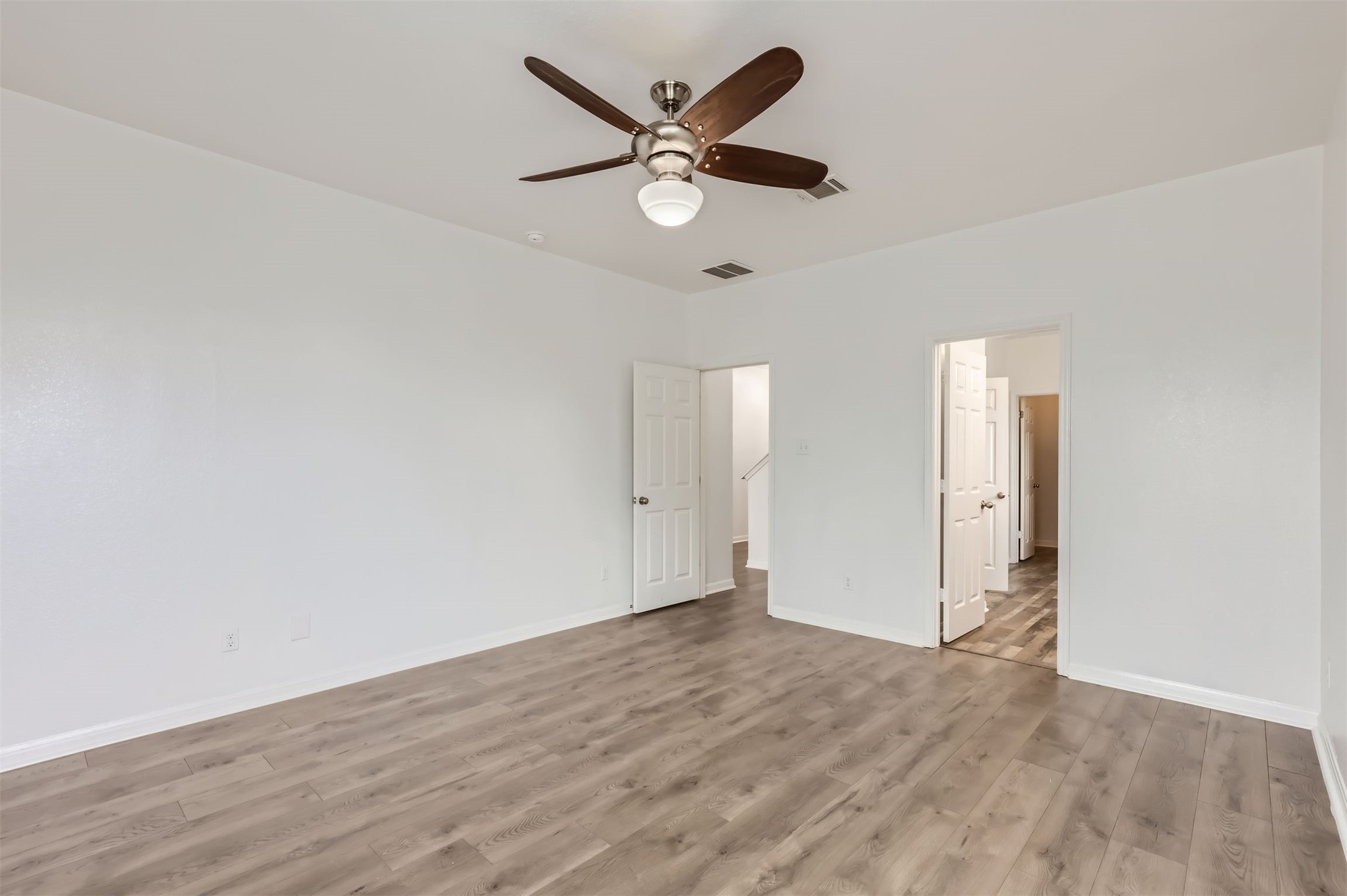 131 Lavaca Loop Hutto, TX 78634 - Photo 10 of 29 A spacious room offers comfortable living with a wood-look floor and ceiling fan.