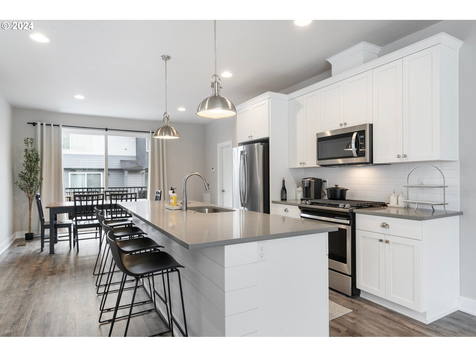 17136 Southwest Woodpecker Lane Beaverton, OR 97007 - Photo 11 of 34 a kitchen with stainless steel appliances granite countertop a stove a sink a microwave a center island and furniture