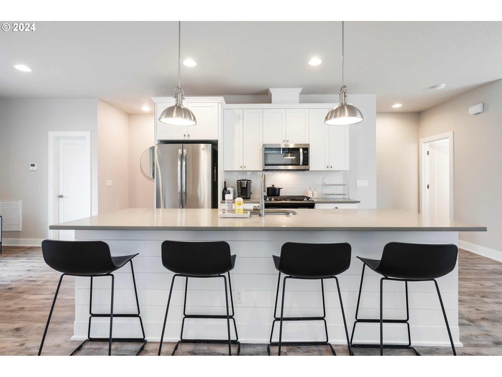 17136 Southwest Woodpecker Lane Beaverton, OR 97007 - Photo 12 of 34 a kitchen with stainless steel appliances kitchen island granite countertop a dining table chairs and a sink