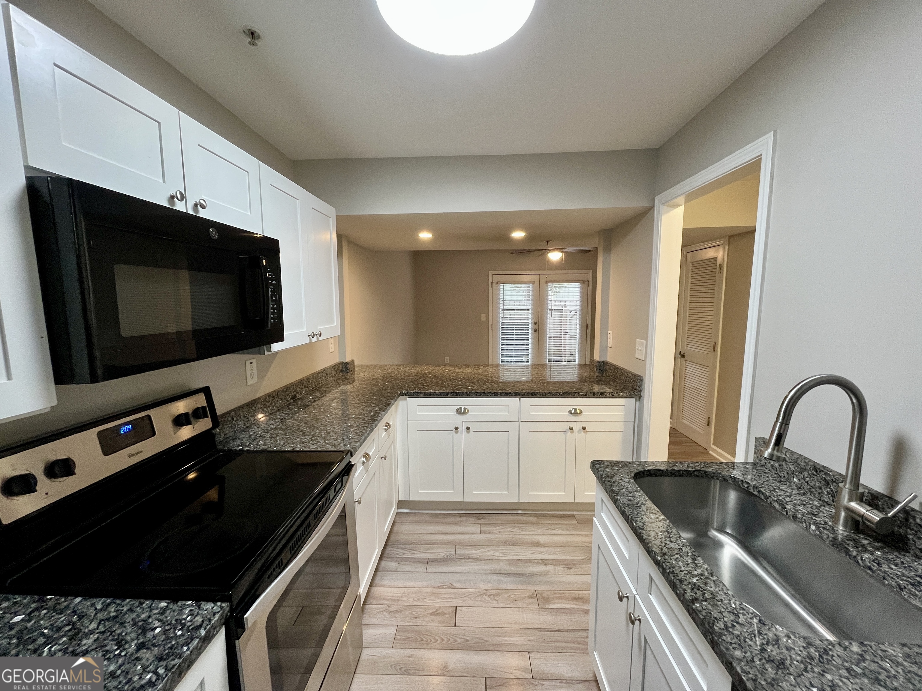 3241 Turner Street, Unit 30 East Point, GA 30344 - Photo 4 of 12 a kitchen with granite countertop a sink and a stove top oven