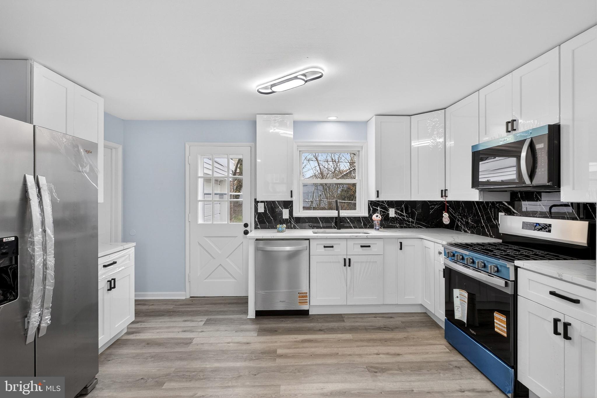 a kitchen with stainless steel appliances a refrigerator sink and microwave