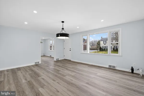 a view of empty room with wooden floor and window