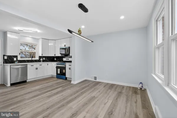 a kitchen with granite countertop a stove top oven and cabinets