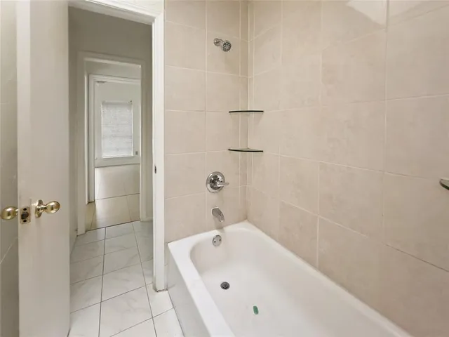 a bathroom with a white bath tub and a shower