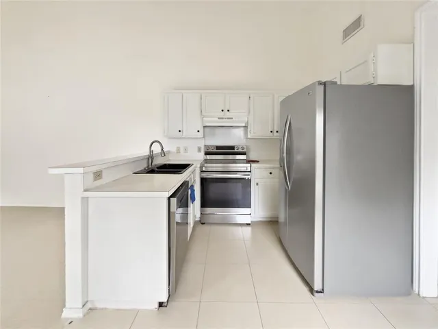 a kitchen with a refrigerator sink and stove