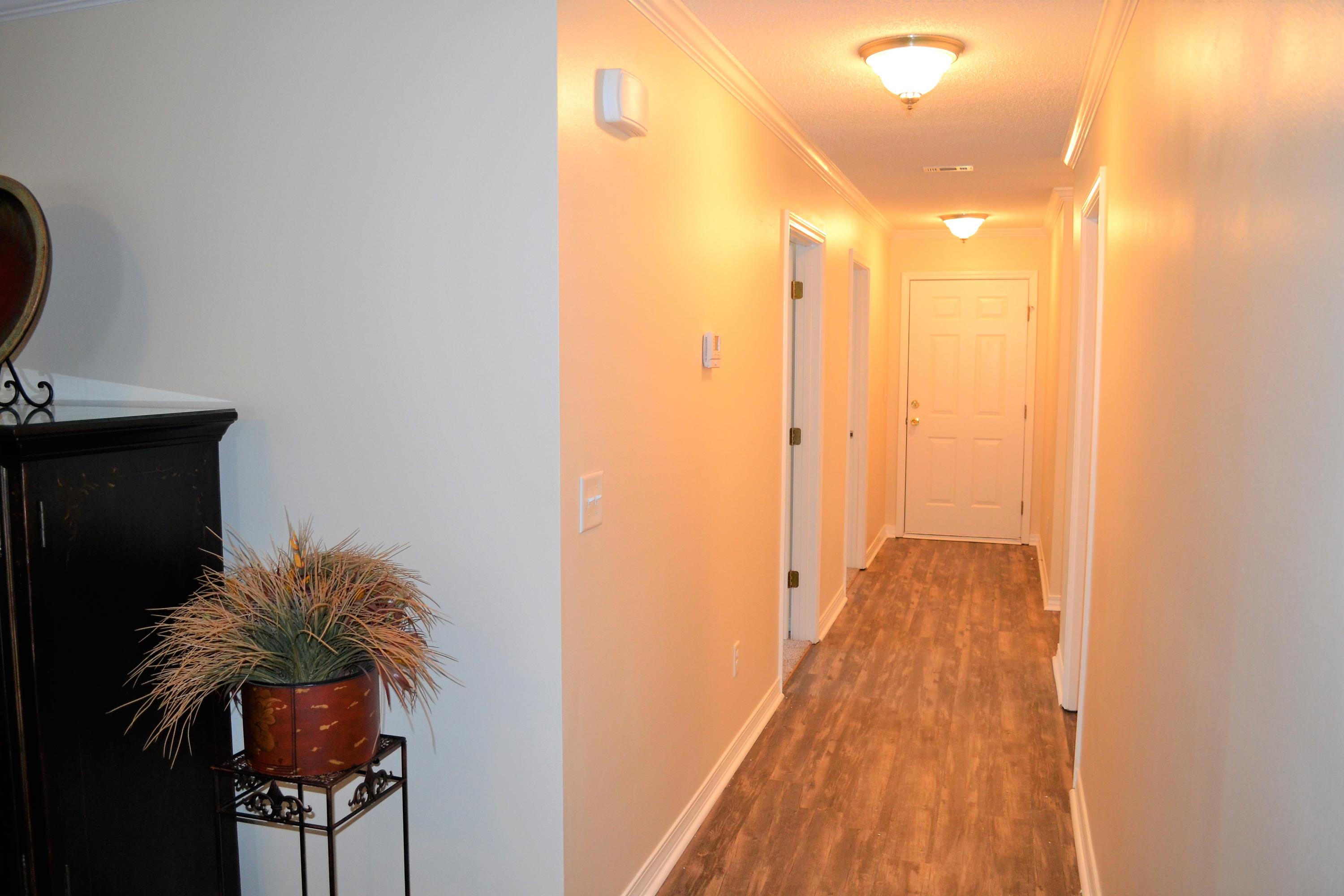 5237 Kervin Road Crestview, FL 32539 - Photo 13 of 28 a view of a hallway with wooden floor and a potted plant